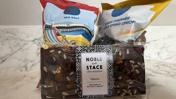 A gift basket with a label reading 'Noble and Stace chocolatiers Tablette' and includes items like sea salt and Sussex chameleon cheese & spring onion.