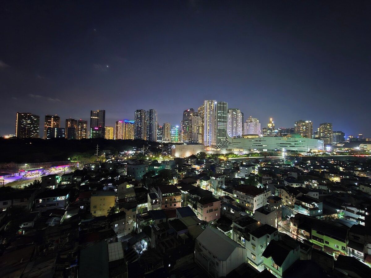 A nighttime cityscape with high-rise buildings and a densely populated residential area.