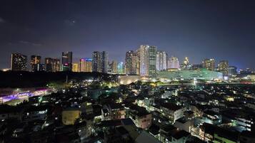 A nighttime cityscape with high-rise buildings and a densely populated residential area.