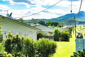 A residential area with houses, a grassy field, and a mountain in the background. - Flinders Peak Estate-Country Villa (Peak Crossing)