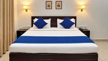 Una habitación de hotel con una cama grande, dos mesitas de noche y lámparas de pared.