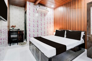 Un dormitorio con cama, armario, tocador y unidad de aire acondicionado.