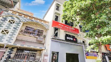 Un edificio con un letrero rojo que anuncia habitaciones disponibles para alquiler mensual.