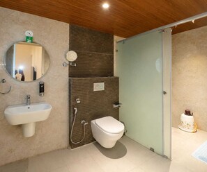 A bathroom with a sink, mirror, toilet, and shower. - Classic Tirumala Hill View Tirupati (Tirupati)
