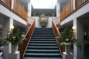 A staircase with wooden railings, flanked by potted plants, leading to a second floor. - Peel Manor House (Karnup)