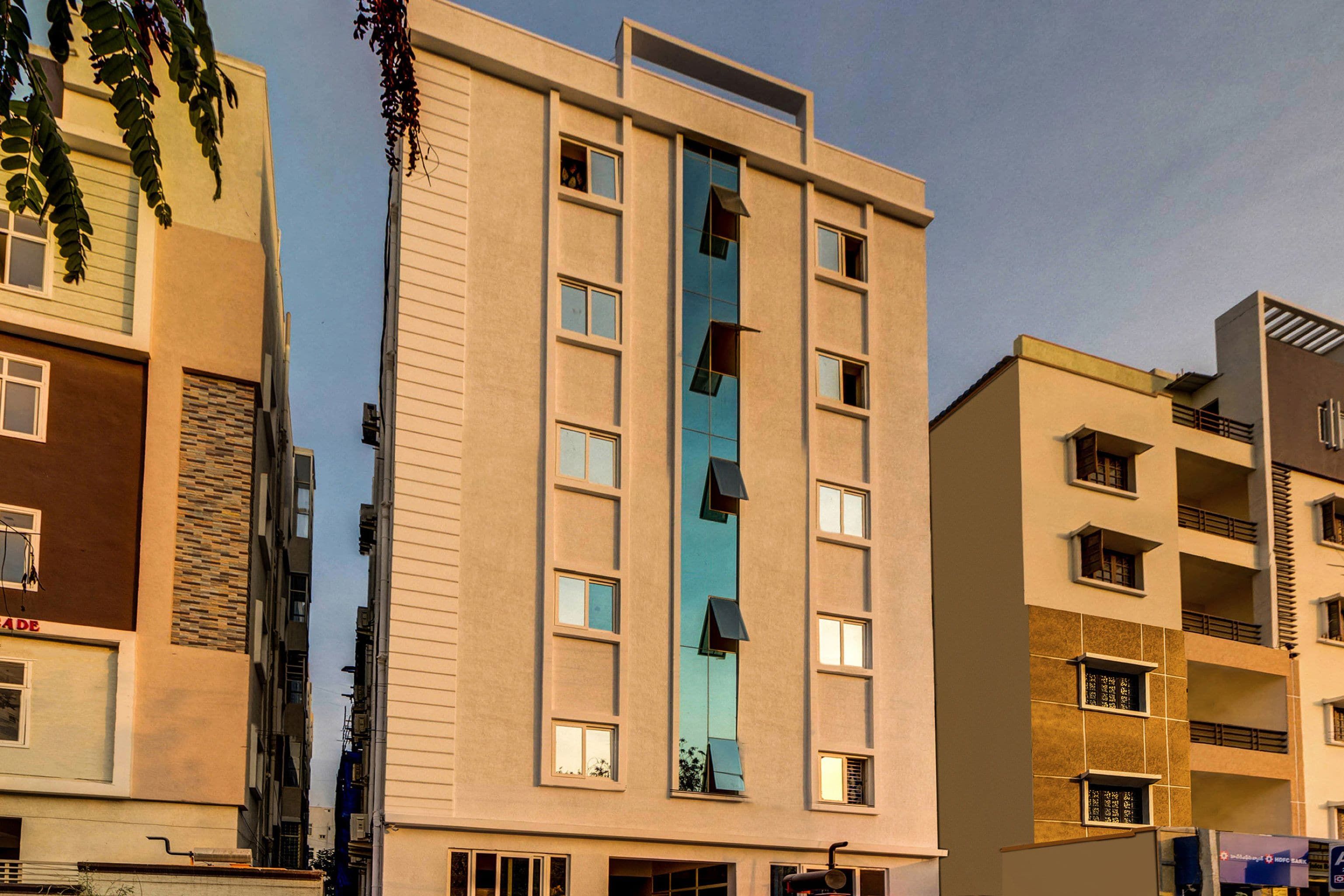 A multi-story building with a central vertical feature, possibly a staircase or elevator shaft, flanked by windows.