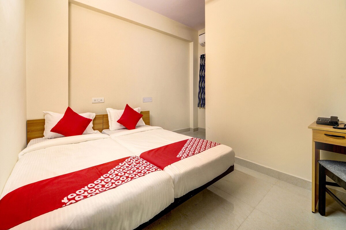 A hotel room with a bed, a desk, and a telephone.