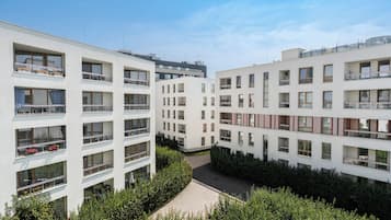 Ein moderner Wohnkomplex mit mehreren Etagen, Balkonen und einem Innenhof.