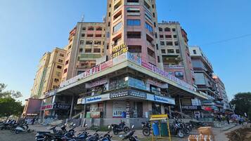 A multi-story building with various commercial establishments on the ground floor, including a hotel, a student visa service, and a hardware store.