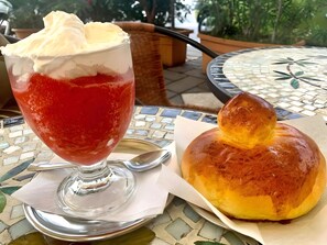 A dessert with whipped cream and a glazed pastry on a table with a mosaic pattern. - Holiday Home 'Dai Maestri Rubino' with Mountain View, Wi-Fi and Air Conditioning (Vita)