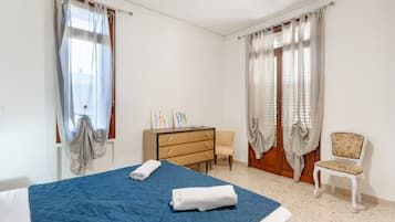 Ein Schlafzimmer mit Bett, Kommode, Stuhl und Schreibtisch.