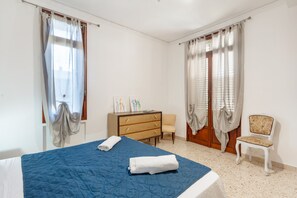 A bedroom with a bed, a dresser, a chair, and a desk.