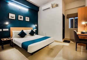 A hotel room with a bed, bedside tables, a desk, and a chair. - Hotel O GACHIBOWLI BESIDE DLF  (Hyderabad)