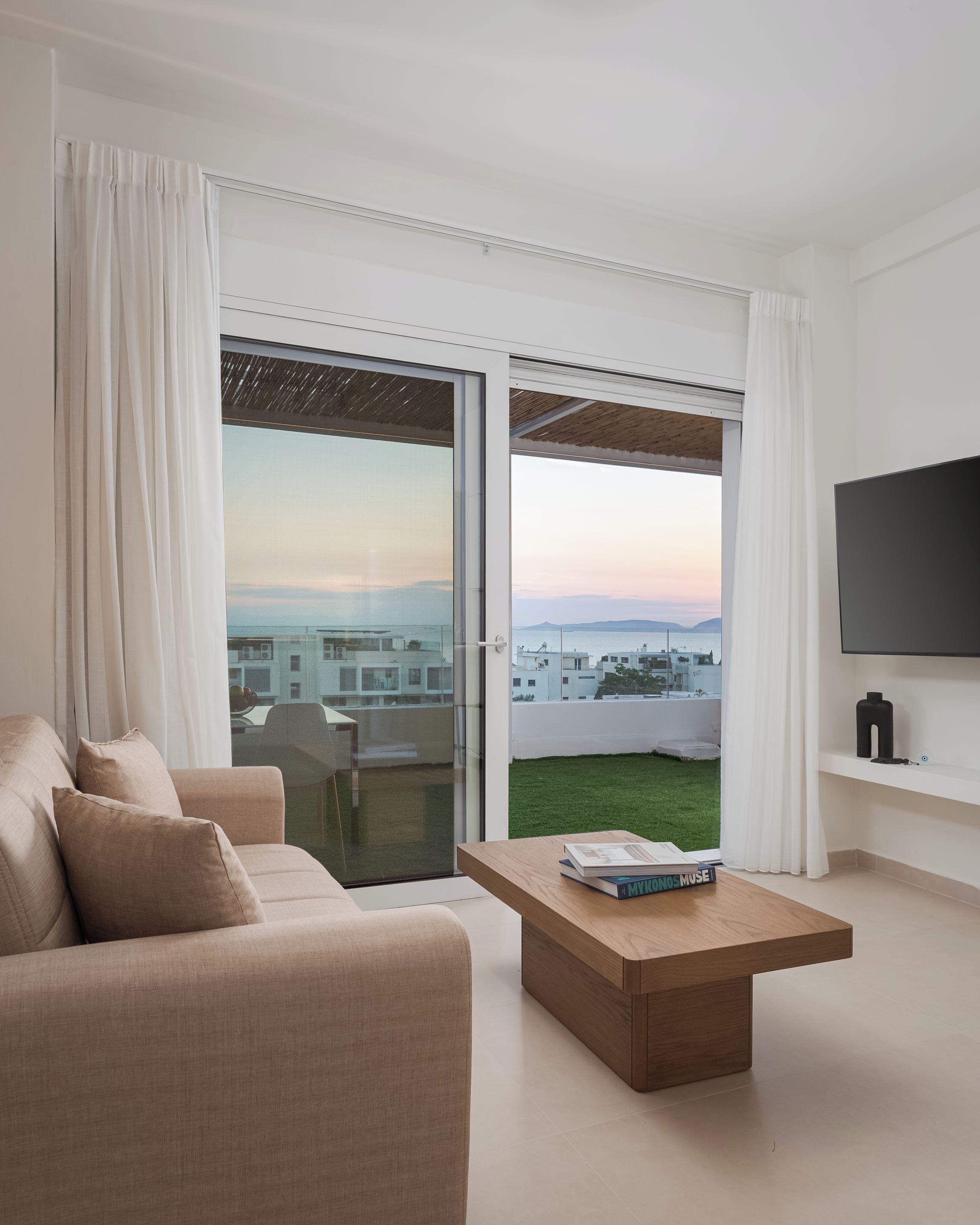 A modern living room with a sofa, a coffee table, and a TV.