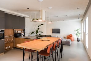 Una cucina moderna con zona pranzo, televisione a schermo piatto e un'ampia finestra.