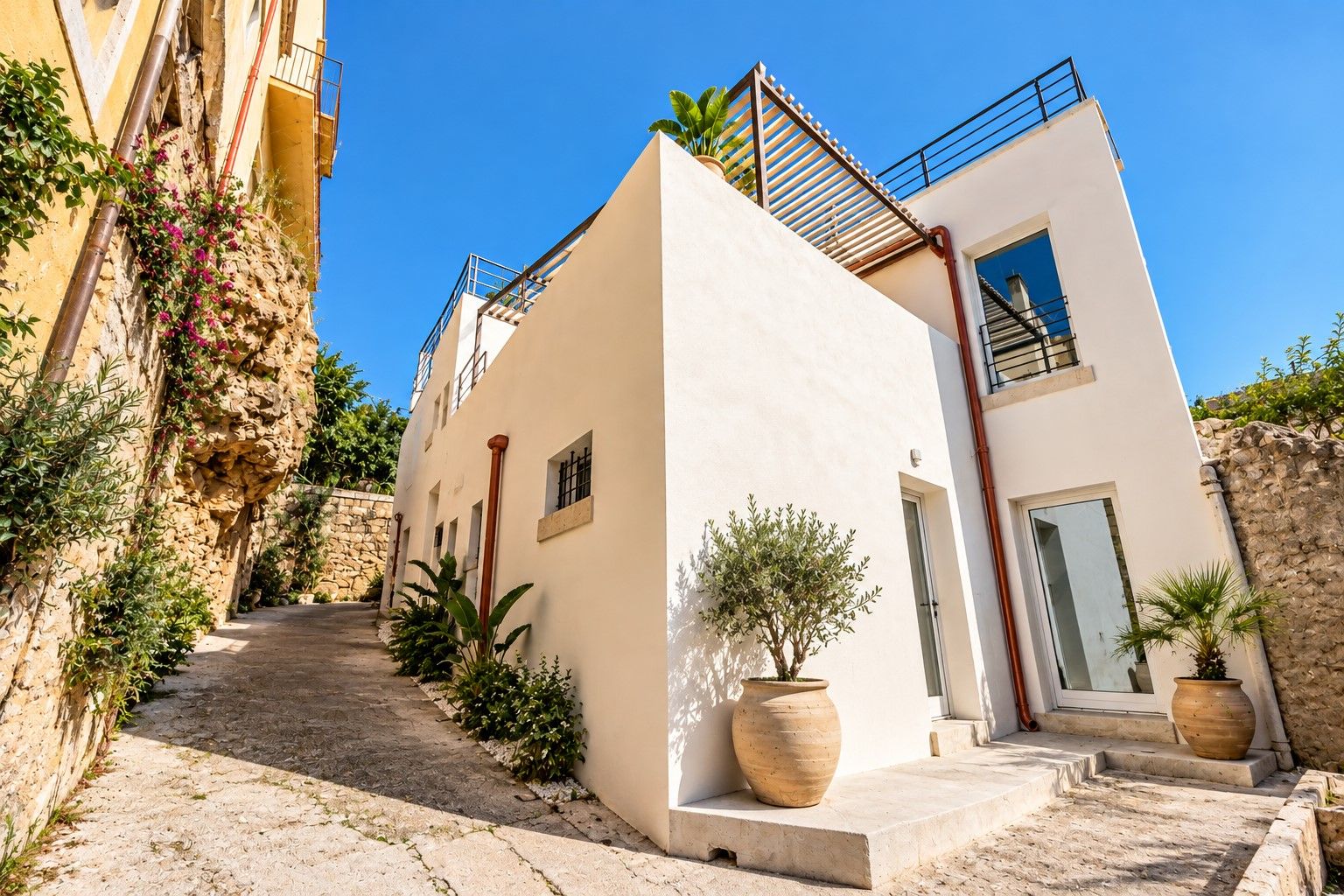 Ein modernes Gebäude mit Naturstein-Fassade, flachem Dach und kleinem Balkon.