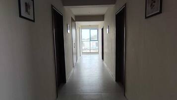 A long, narrow hallway with doors on both sides leading to rooms.