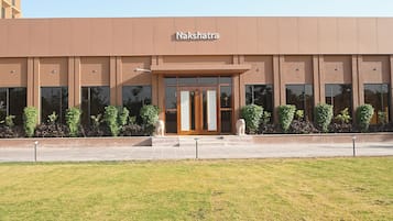 A building with the sign 'Nakshatra' above the entrance, featuring a modern design with large windows and a flat roof.