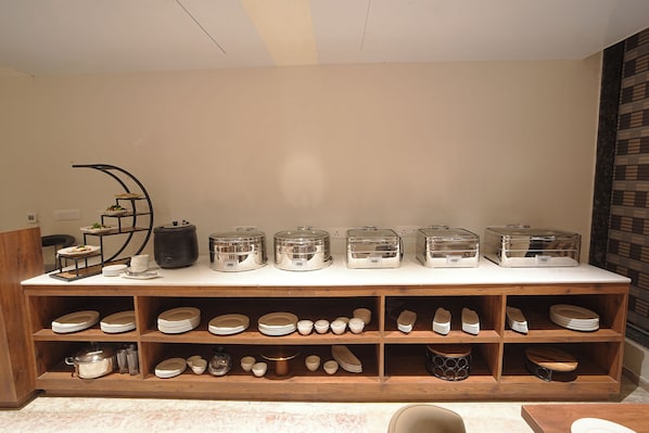 A buffet setup with multiple serving stations, including a variety of dishes and utensils.