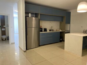 A modern kitchen with a stainless steel refrigerator, a microwave, and a sink. - Mesilat Yesharim Penthouse  (Jerusalem)