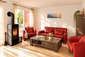 Ein Wohnzimmer mit Kamin, roten Ledersofas, einem Couchtisch und einem Gemälde an der Wand.