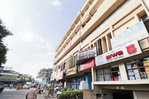 Un edificio de varios pisos con diversos comercios en la planta baja, incluyendo un hotel y una tienda de electricidad.