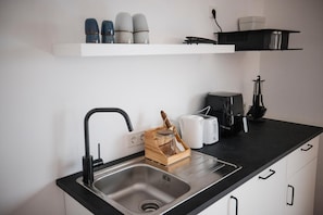 Eine moderne Küche mit einer Spüle aus Edelstahl, einem Toaster und einer Kaffeemaschine auf der Arbeitsfläche.