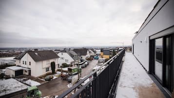 Ein Wohngebiet mit Häusern, einer Straße und einem schneebedeckten Balkon.