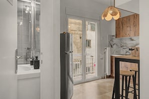 Una cocina moderna con refrigerador, lavamanos y comedor con taburetes.