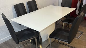 Una sala de conferencias con una mesa blanca y sillas negras.