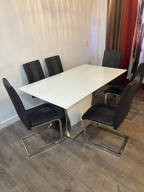 Een vergaderzaal met een witte tafel en zwarte stoelen.