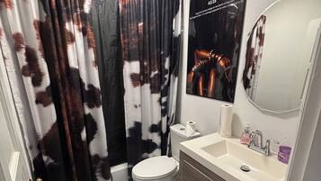 Ein Badezimmer mit Toilette, Waschbecken und Duschvorhang.