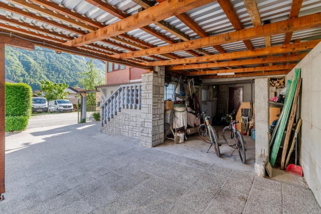 Un espace extérieur abrité, doté d’un escalier en pierre menant à un garage.