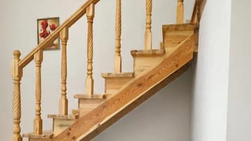 Una escalera de madera conduce a un comedor con una mesa y sillas.