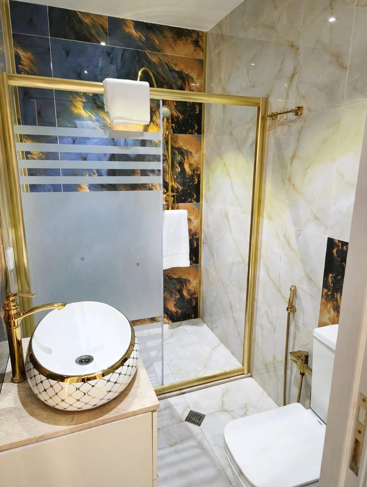 Un baño con lavamanos redondo, ducha e inodoro.