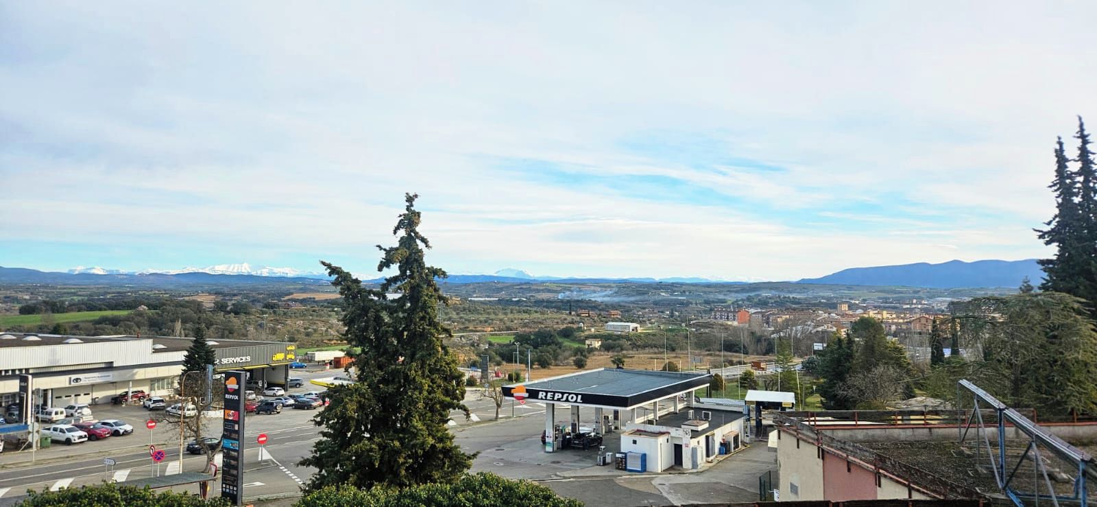 A gas station with a clear view of a mountainous landscape in the background.
