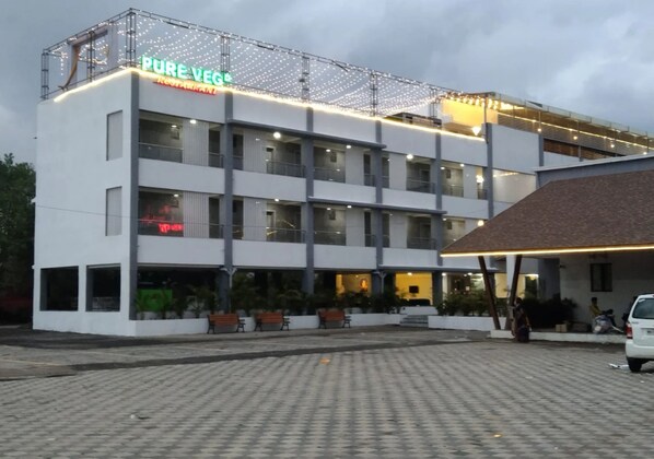 A multi-story building with a sign reading 'PURE VEG Restaurant.'