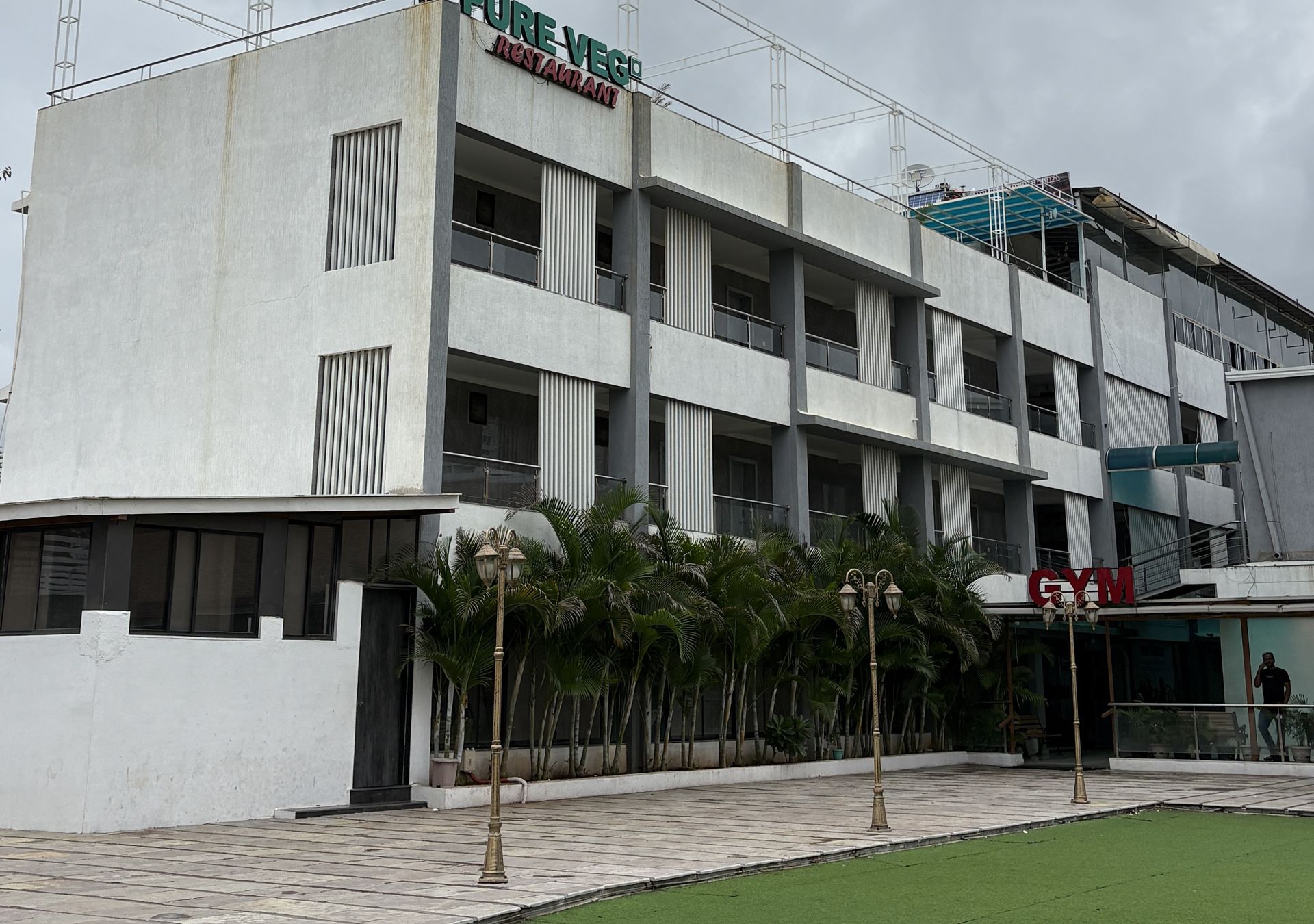 Un edificio de varios pisos con restaurante y gimnasio en la planta baja.
