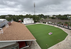 Een stadion met een groen veld, een bakstenen dak en een wit gebouw op de achtergrond.