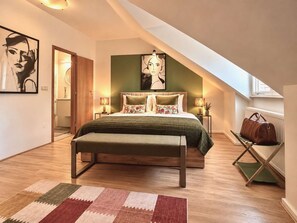 Ein Schlafzimmer mit Bett, Bank und Blick ins Freie.