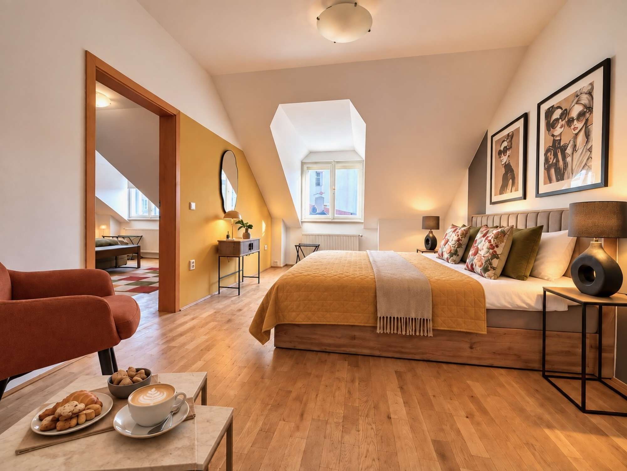 A modern bedroom with a large bed, a sitting area with a chair and table, and a view of the city through a window.