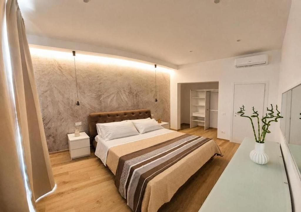 Une chambre à coucher moderne comprenant un lit, des tables de chevet, une commode, une coiffeuse et un miroir.