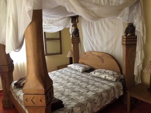 A four-poster bed with a canopy, a wooden headboard, and a patterned bedspread. - Villa African Dream for 5 People (Diani Beach)