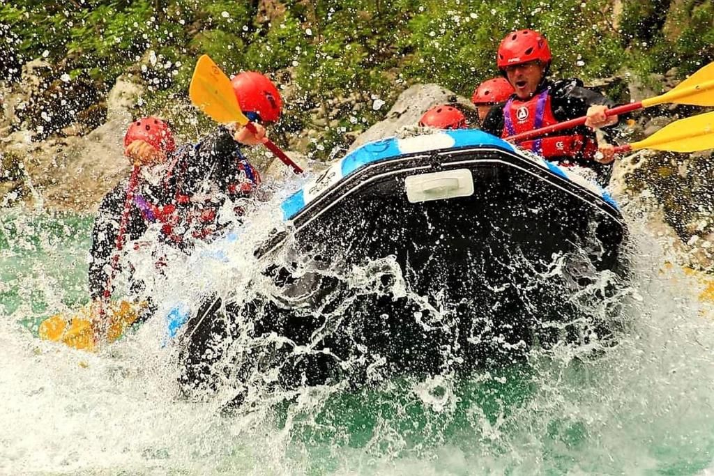 A group of people in a raft navigating through a river with splashing water.