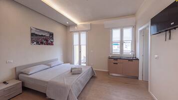 A modern bedroom with a bed, bedside table, and a large window.