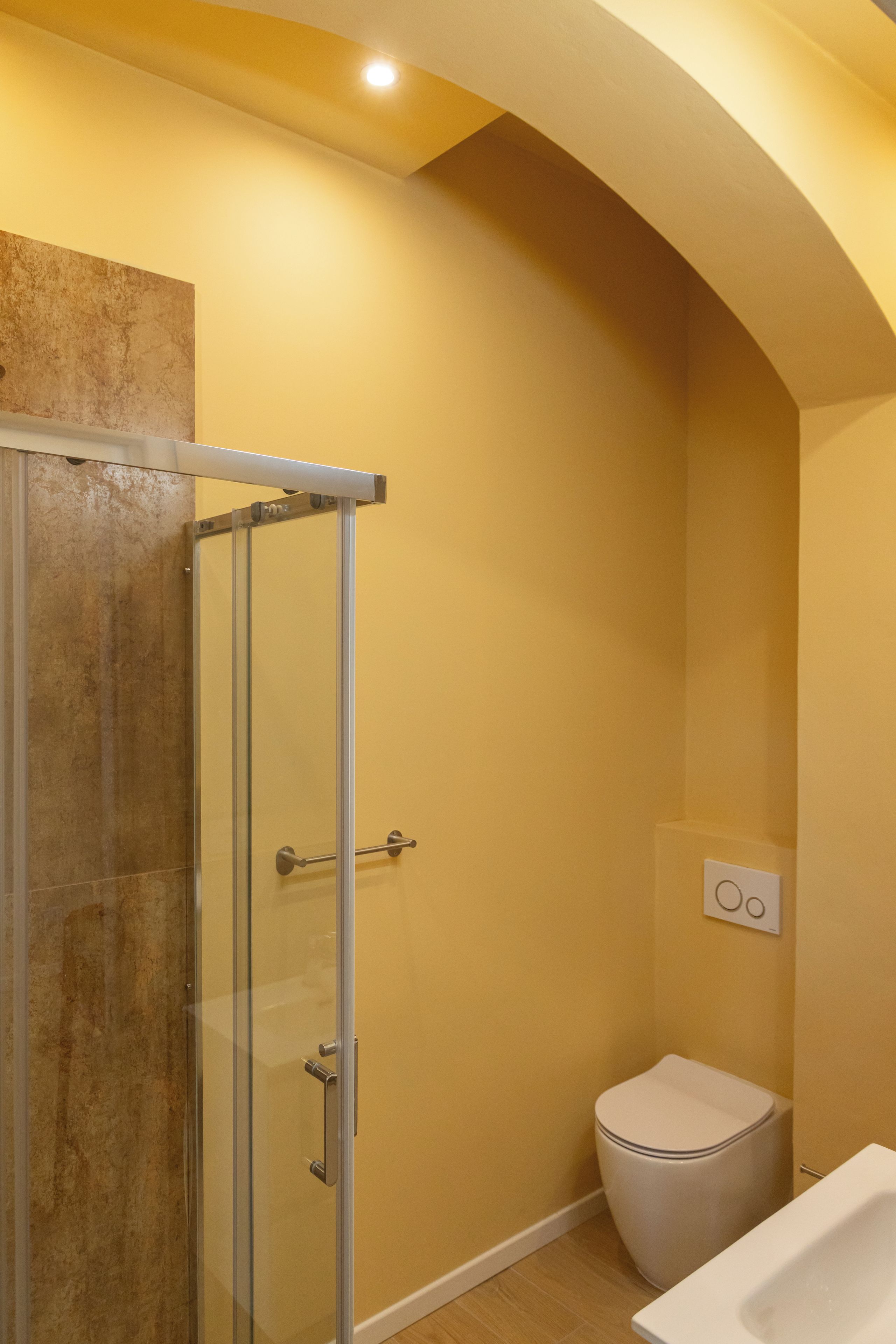 A bathroom with a glass shower enclosure, a toilet, and a bathtub.