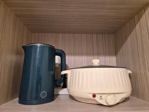 Eine Küche mit Wasserkocher und Slow Cooker auf einer Holzausziehtisch.