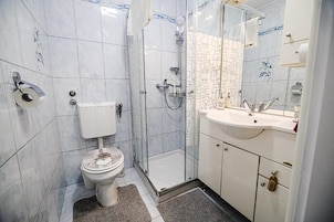 Un baño con inodoro, ducha y lavamanos.