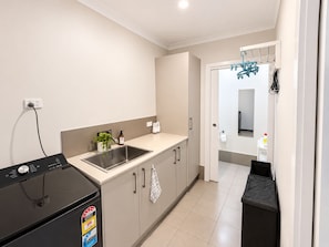 A modern kitchen with a built-in dishwasher, a sink, and a countertop. - Stylish 4-Bed Terrace | Modern & Convenient (Throsby)