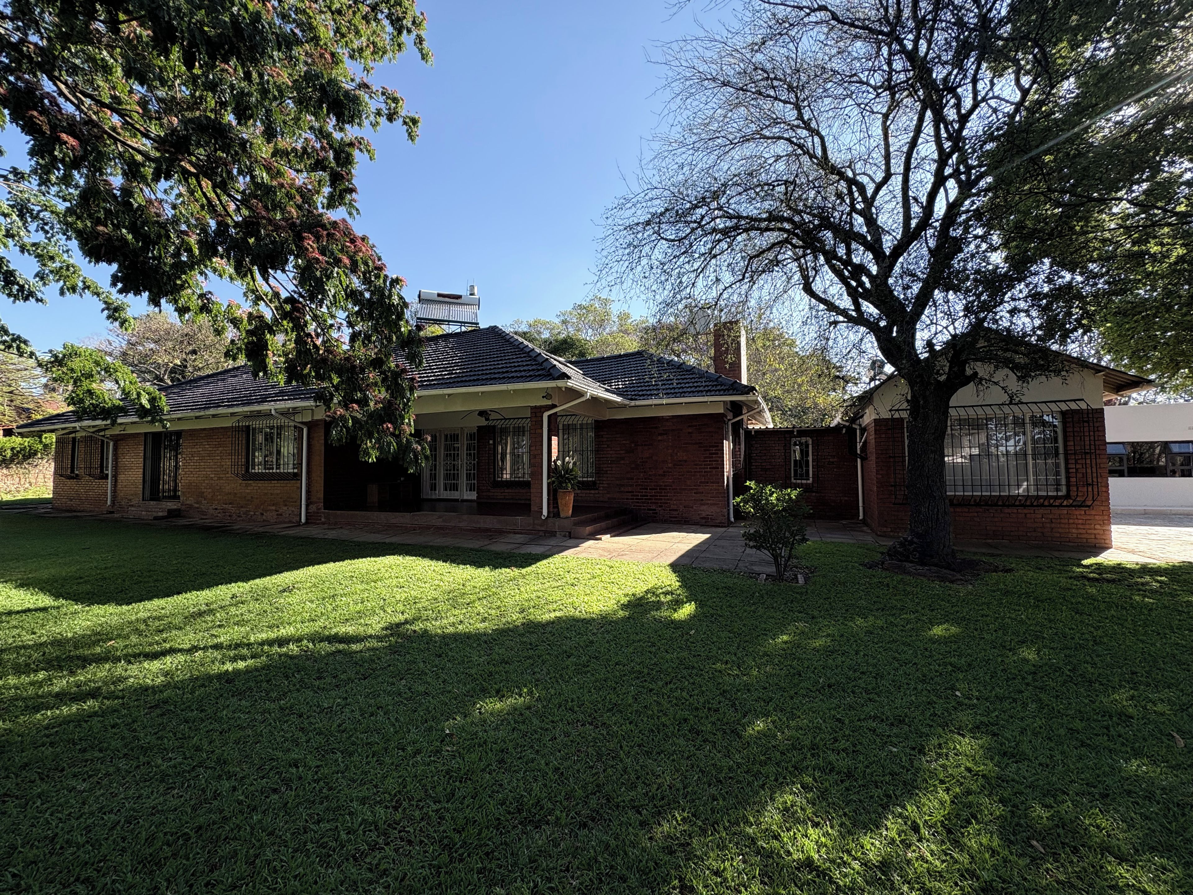 A two-story house with a brick exterior, a covered porch, and a well-maintained lawn.